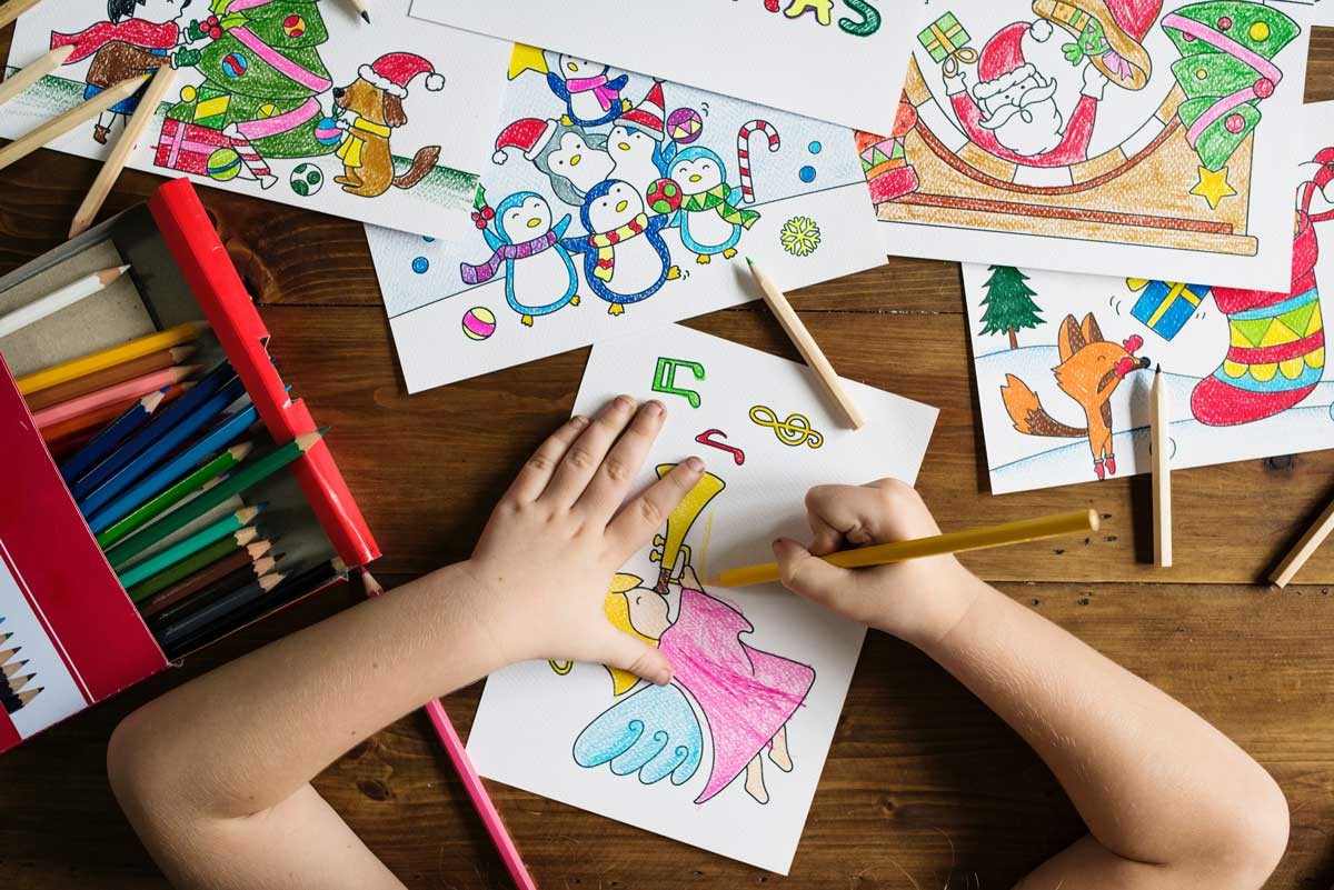 niño dibujando dibujos encima de una mesa de madera